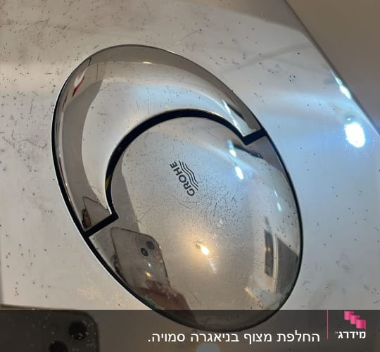 לחצן הדחה של אסלה עם לוגו גרואה